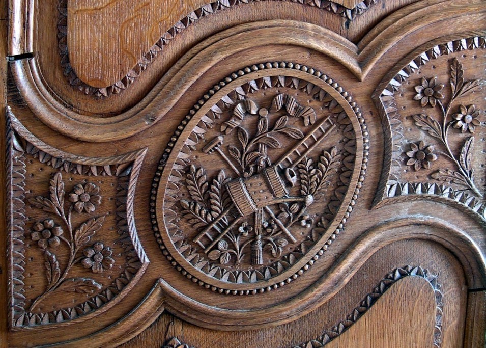 Médaillon sculpté d’une armoire normande de Vire représentant les instruments aratoires